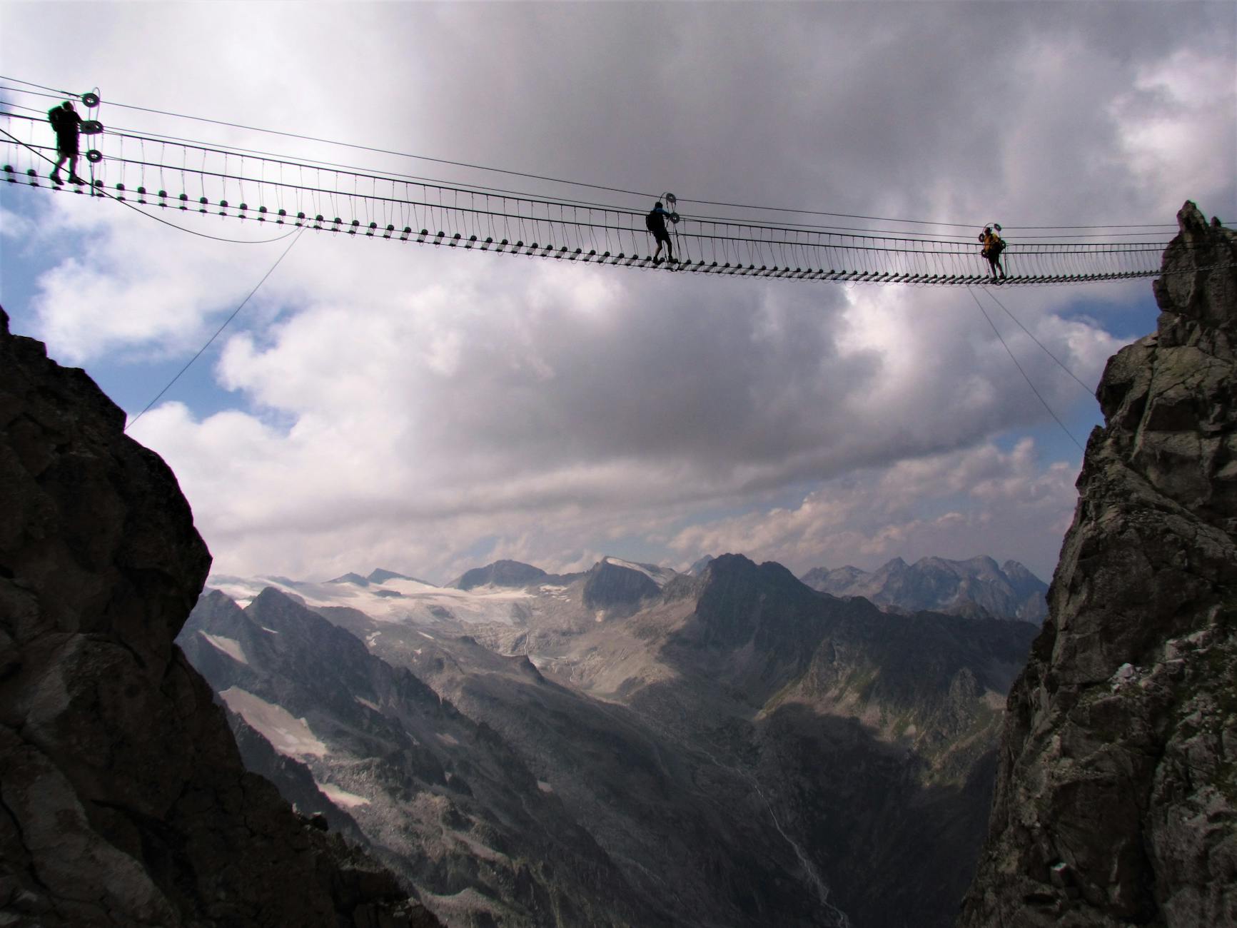people crossing a rope suspension bridge